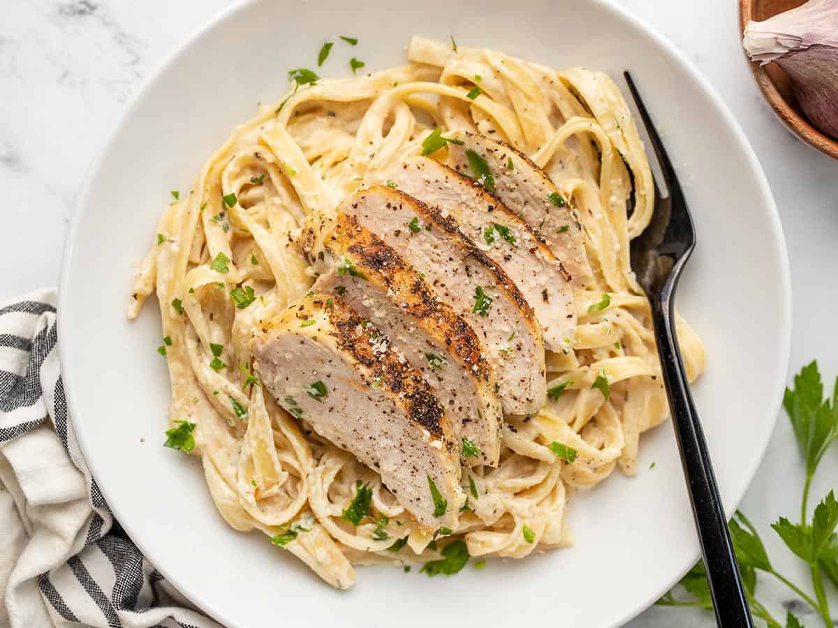 a delicious plate of alfredo pasta topped with chicken